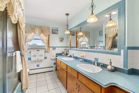 a bathroom with a granite countertop sink mirror and a bath tub