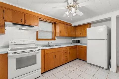 a kitchen with a refrigerator sink and cabinets