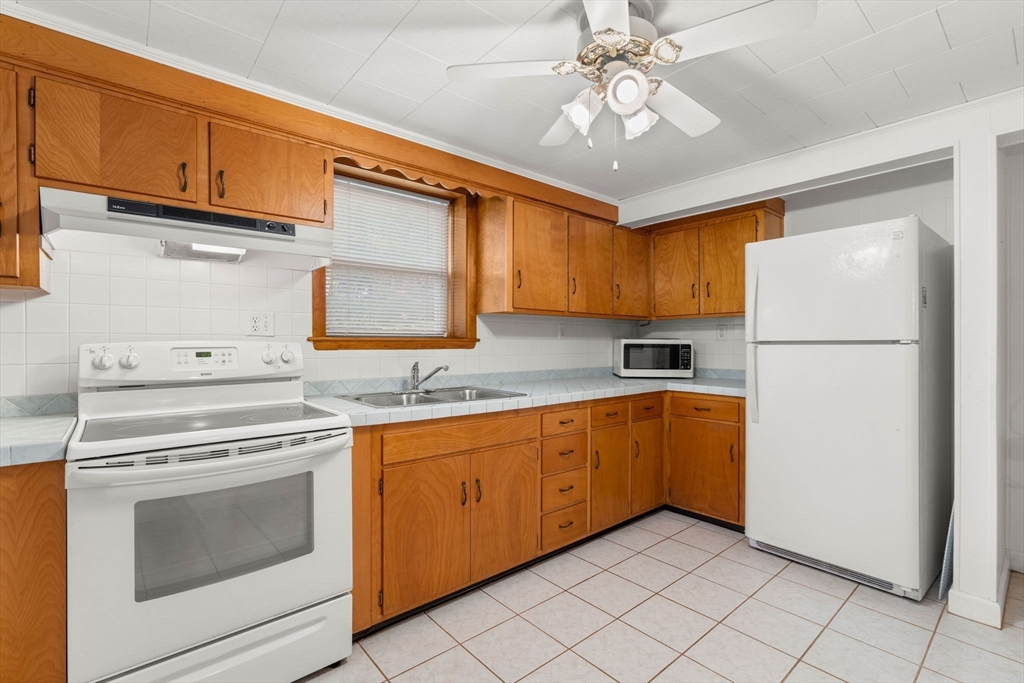 8 Agnes Terrace Methuen, MA 01844 - Photo 27 of 41 a kitchen with a refrigerator sink and cabinets