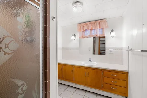 a bathroom with a granite countertop sink and a mirror