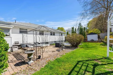 a view of a house with backyard and sitting area
