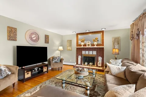 a living room with furniture a flat screen tv and a fireplace