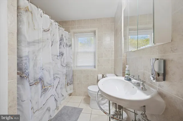 a bathroom with a sink toilet a mirror and shower