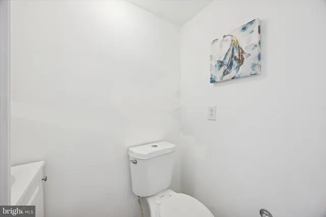 a white toilet sitting next to a white wall
