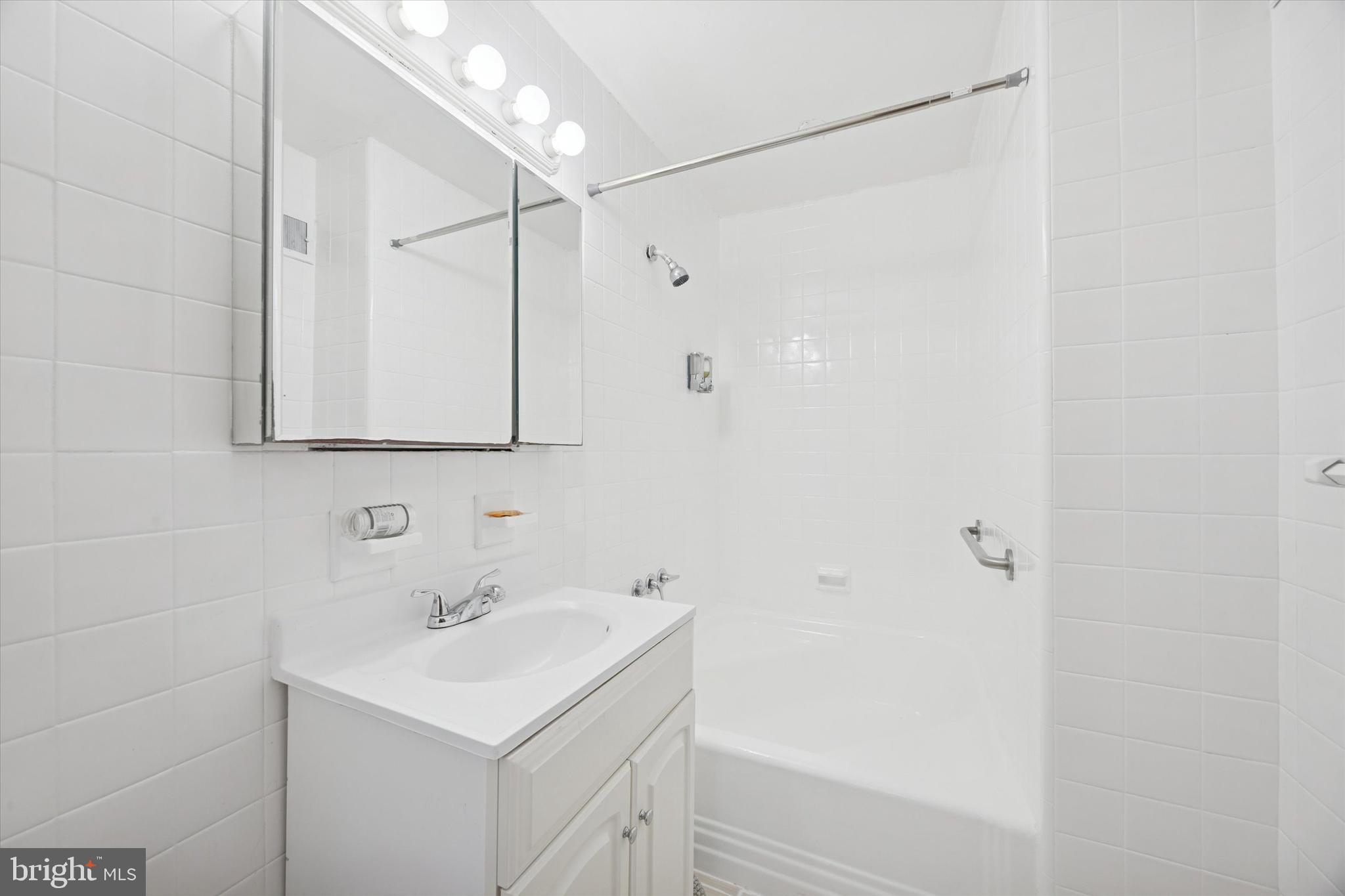 7033 Sherwood Road Philadelphia, PA 19151 - Photo 14 of 16 a bathroom with a sink a shower and a mirror