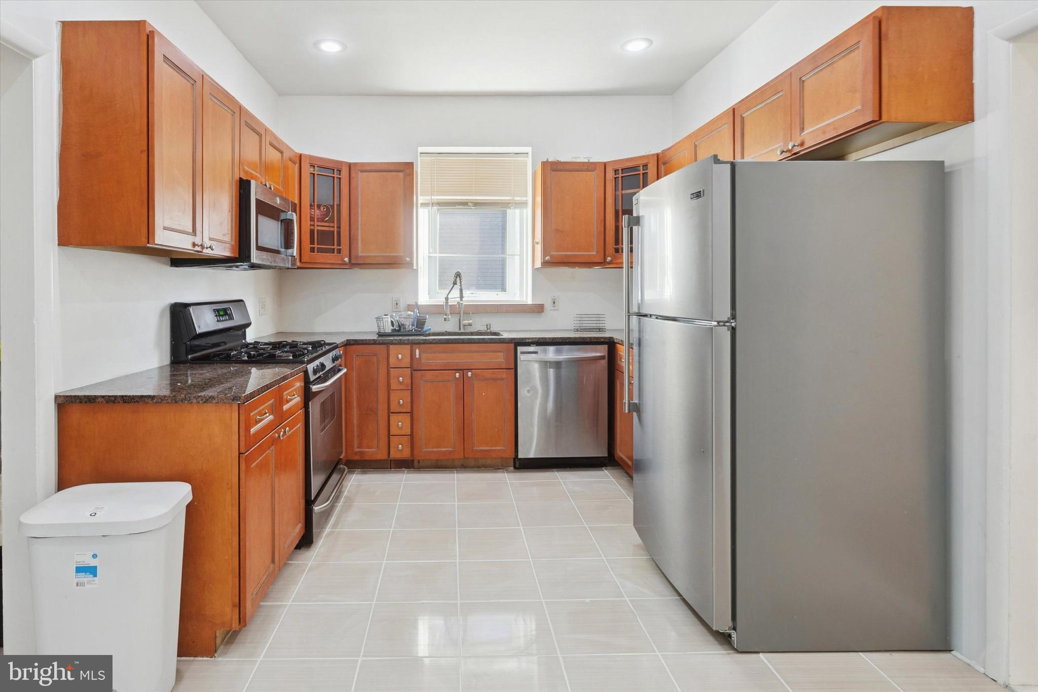 7033 Sherwood Road Philadelphia, PA 19151 - Photo 7 of 16 a kitchen with stainless steel appliances granite countertop a refrigerator a sink dishwasher a stove with wooden cabinets
