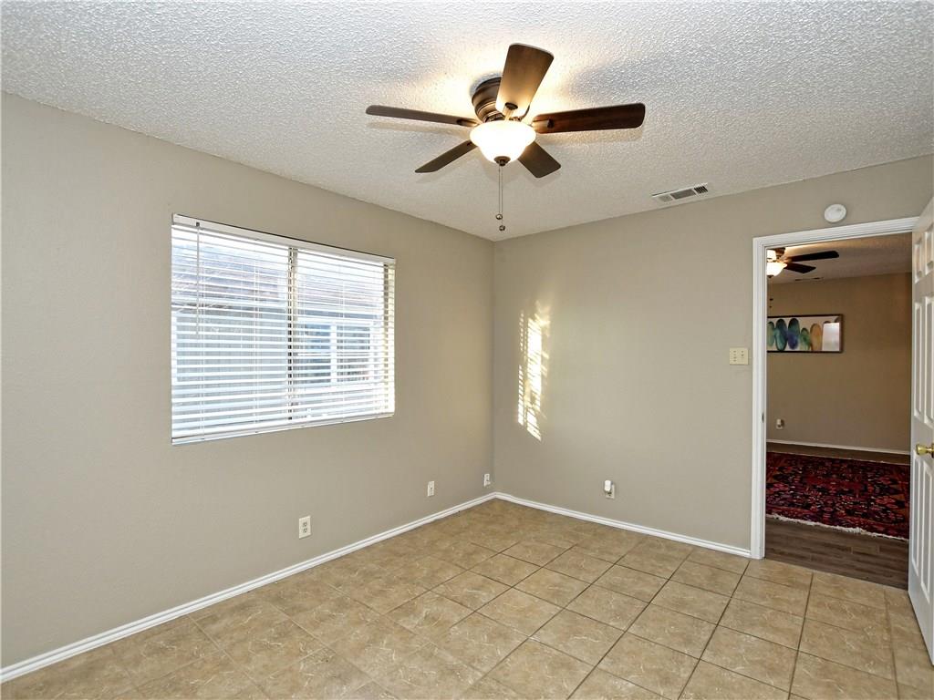 5401 Spring Meadow Road, Unit B Austin, TX 78744 - Photo 11 of 21 A window-lit room features a ceiling fan, providing comfort and natural light.