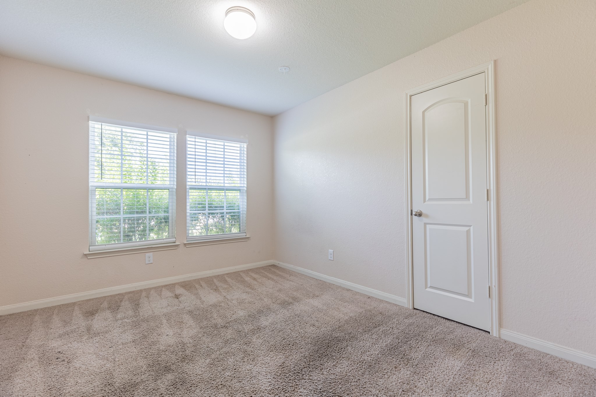 20017 Hubert R Humphrey Road Manor, TX 78653 - Photo 4 of 35 A well-lit bedroom features plush carpeting and multiple windows for abundant natural light.