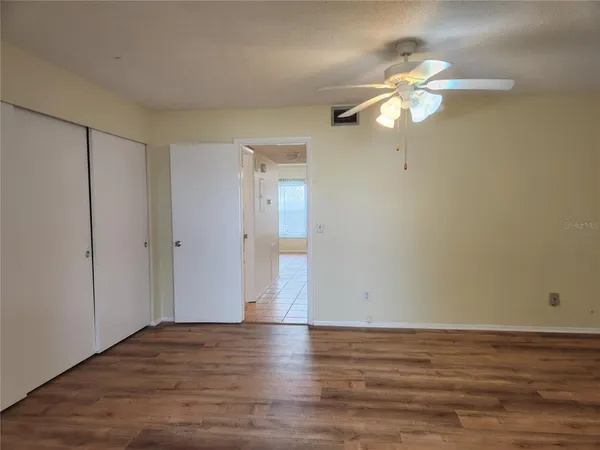 a view of an empty room with wooden floor