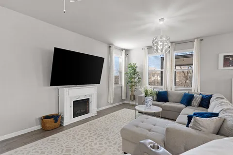 a kitchen with stainless steel appliances granite countertop a stove a sink a refrigerator a microwave oven with white cabinets and wooden floor