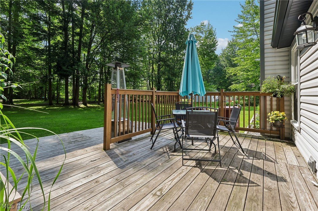 3213 Bates Road Madison, OH 44057 - Photo 33 of 45 Expansive wood-finish deck with a wood railing, offering a clear view of the surrounding forested area