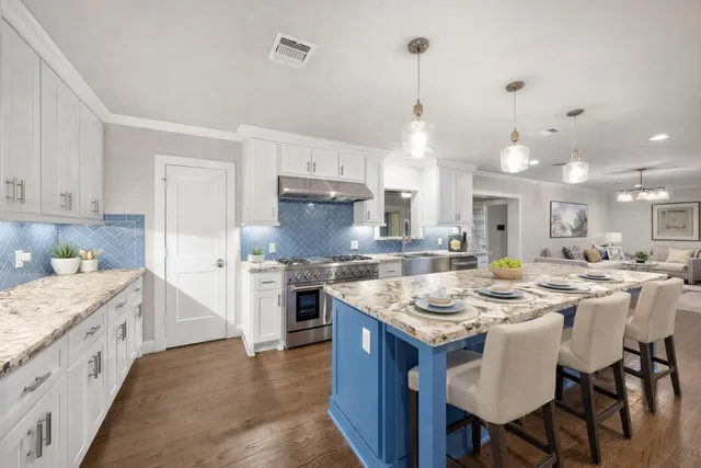 a kitchen with stainless steel appliances granite countertop a sink stove and refrigerator