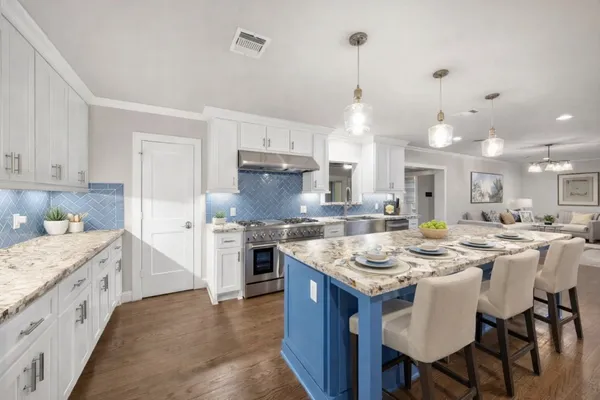 a kitchen with stainless steel appliances granite countertop a sink stove and refrigerator
