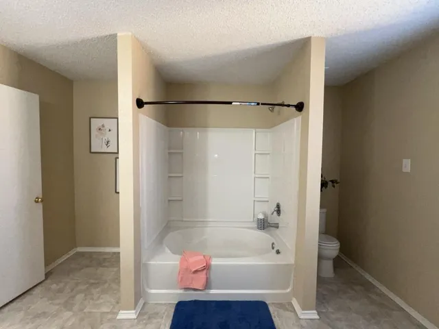 a bathroom with a toilet and a bath tub