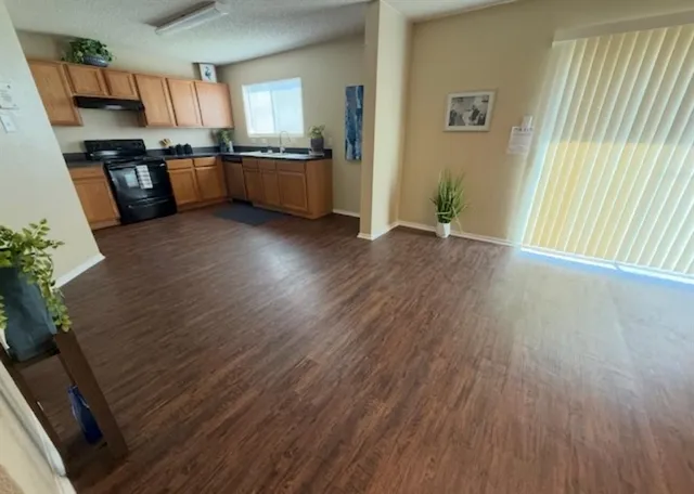 a large kitchen with stainless steel appliances wooden floors and wooden cabinets