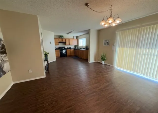 a view of a room with wooden floor staircase and a kitchen