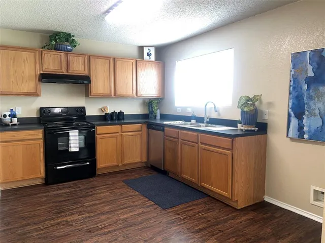 a kitchen with a sink a stove and cabinets