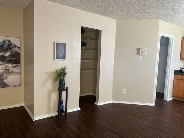 an empty room with wooden floor and closet
