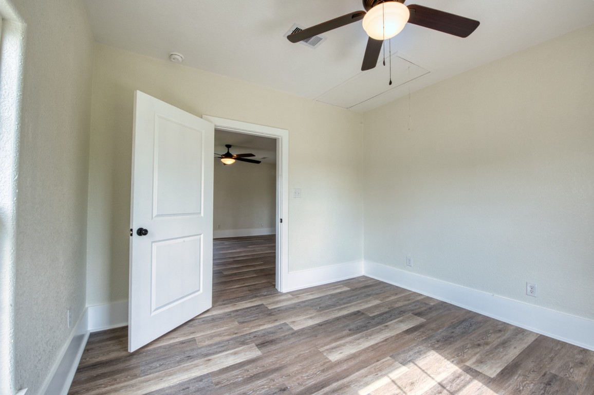 1122 West 2nd Street Freeport, TX 77541 - Photo 18 of 38 an empty room with wooden floor cabinet and ceiling fan