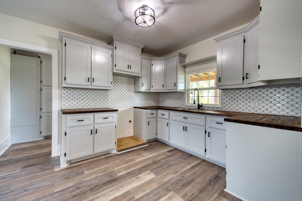 1122 West 2nd Street Freeport, TX 77541 - Photo 7 of 38 a kitchen with granite countertop white cabinets and white appliances