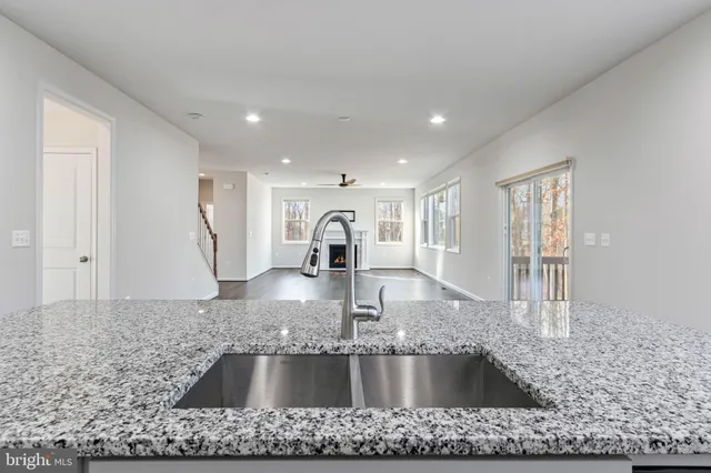 a kitchen with stainless steel appliances granite countertop a stove a refrigerator and white cabinets