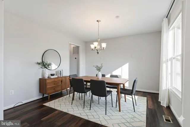 a large kitchen with stainless steel appliances granite countertop a stove a sink a refrigerator and white cabinets with wooden floor