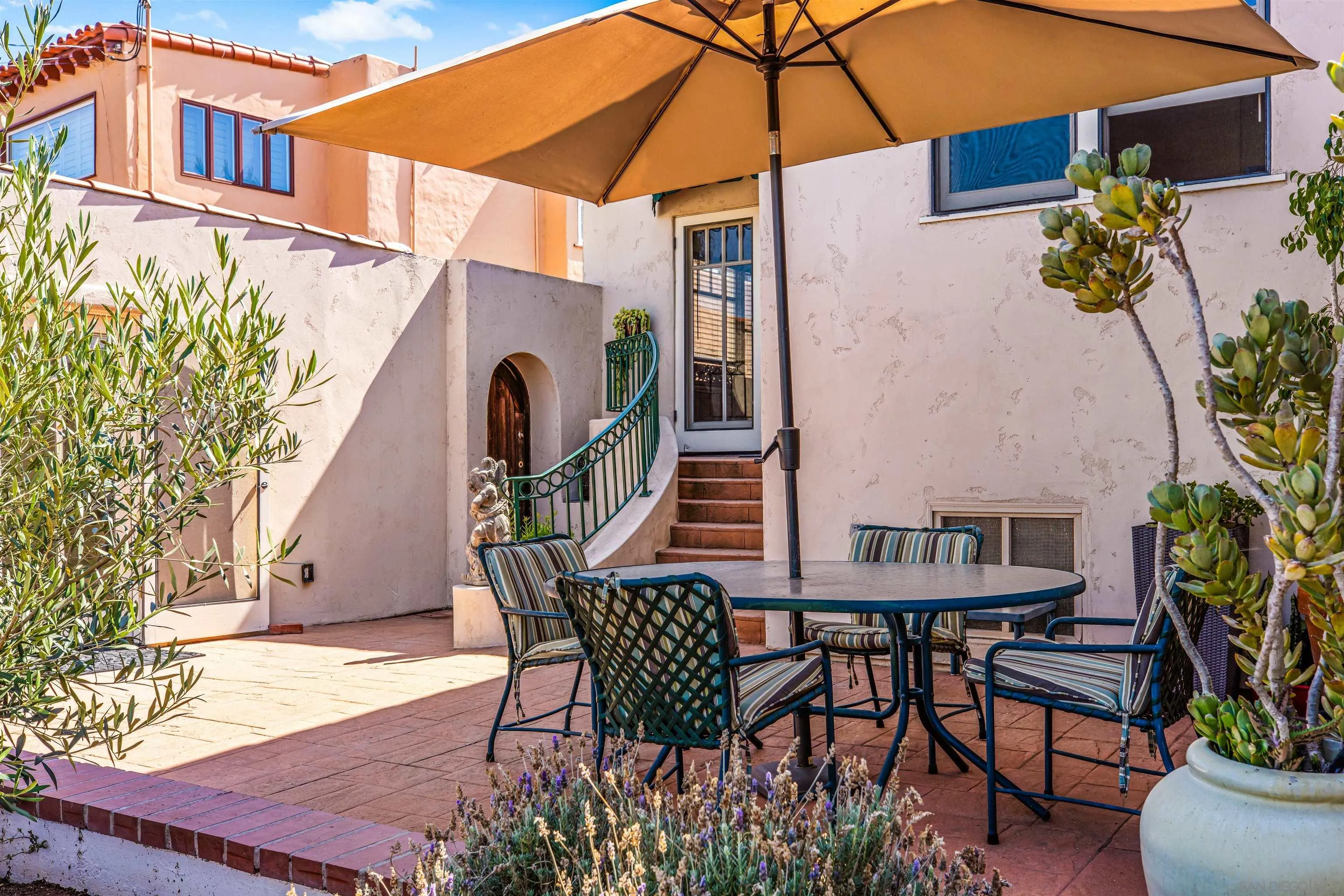 4192 Rochester Road San Diego, CA 92116 - Photo 36 of 38 a patio with a table and chairs under an umbrella