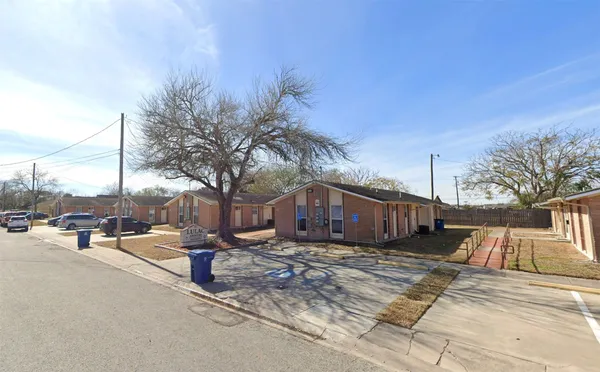 a view of a house with wooden fence next to a road
