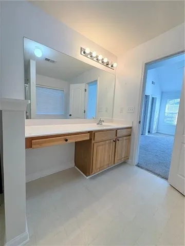 a large white kitchen with a sink a stove and cabinets