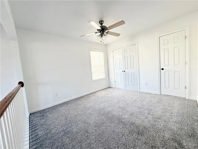 a view of a livingroom with a ceiling fan & window