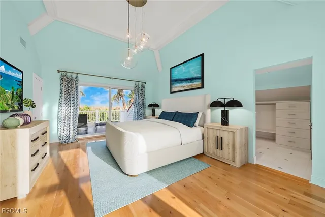 a bedroom with a bed and a flat tv screen on dresser