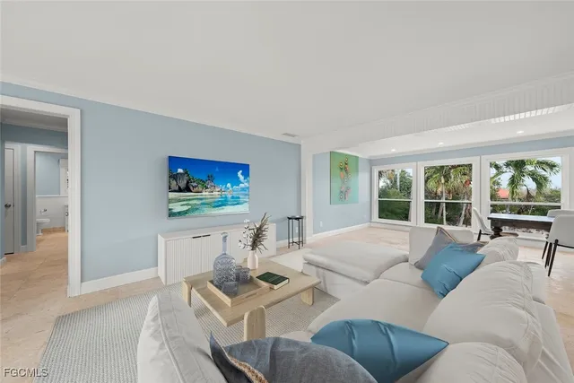 a living room with furniture a large window and a flat screen tv