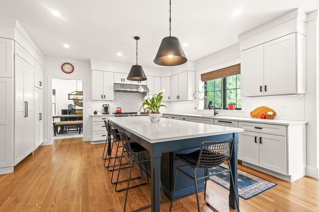 231 Marrett Road Lexington, MA 02421 - Photo 6 of 24 a kitchen with stainless steel appliances a dining table chairs stove and white cabinets