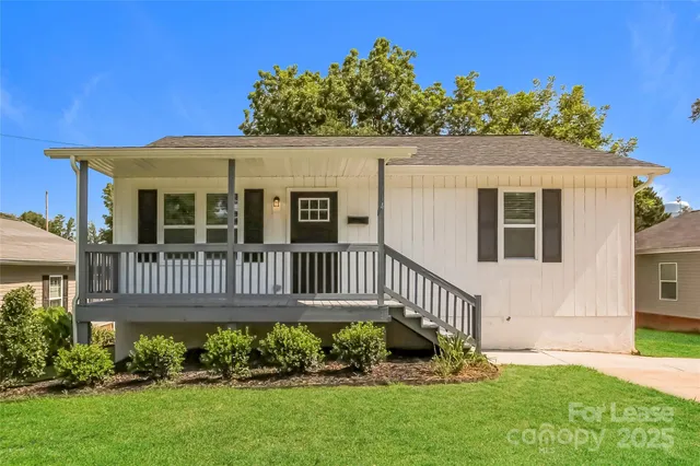 a view of a house with a small yard and wooden fence