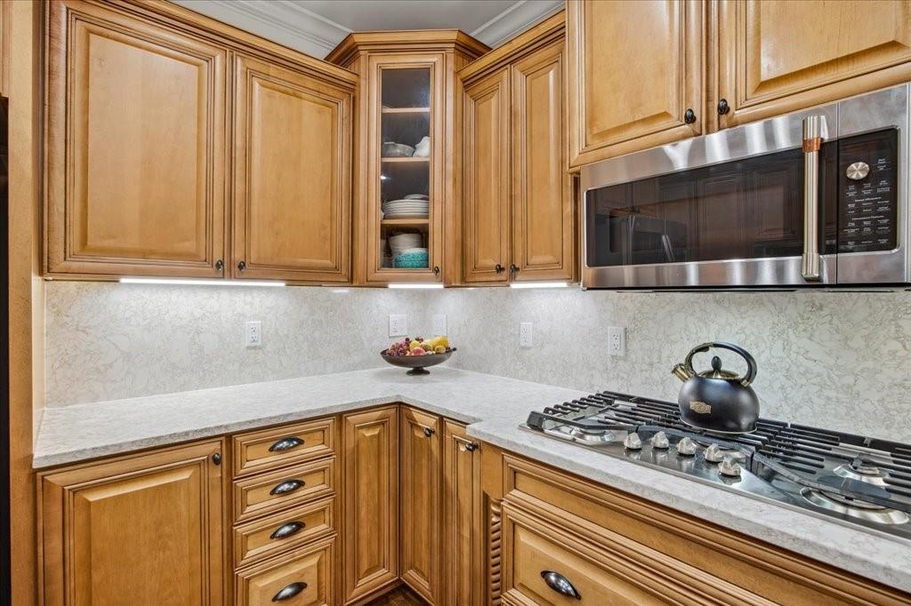 397 Thomas Road Dallas, GA 30132 - Photo 29 of 108 a kitchen with stainless steel appliances wooden cabinets and a stove top oven