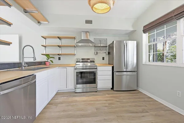 a kitchen with stainless steel appliances a refrigerator sink and cabinets