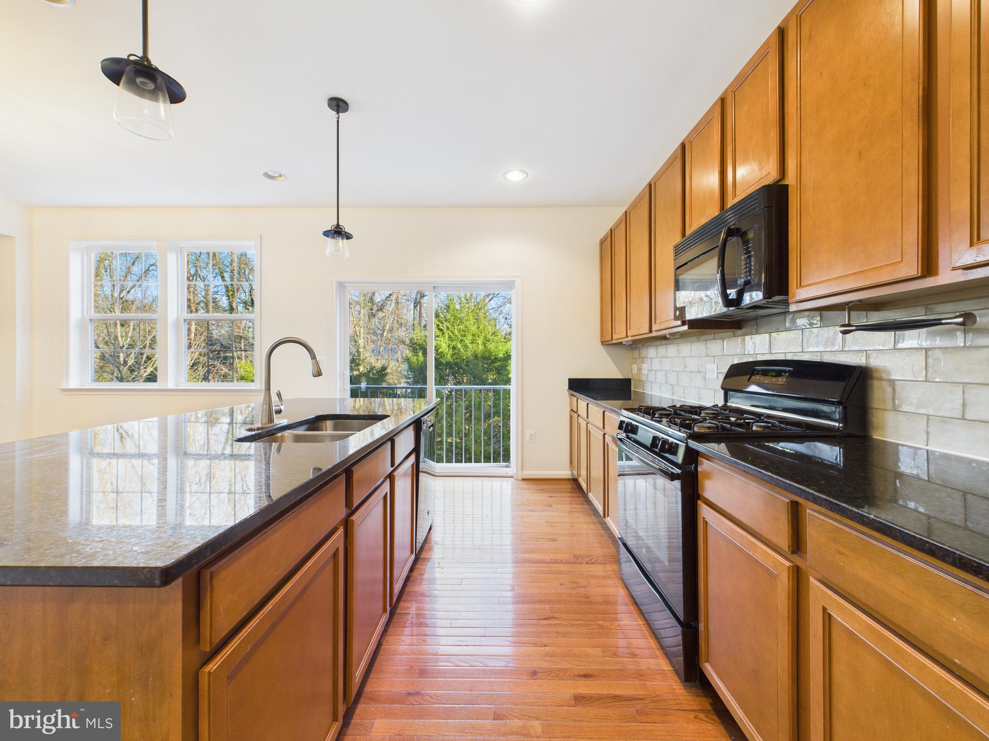 18213 Jillian Lane Triangle, VA 22172 - Photo 11 of 41 a kitchen with stainless steel appliances granite countertop a stove a sink and a wooden floors