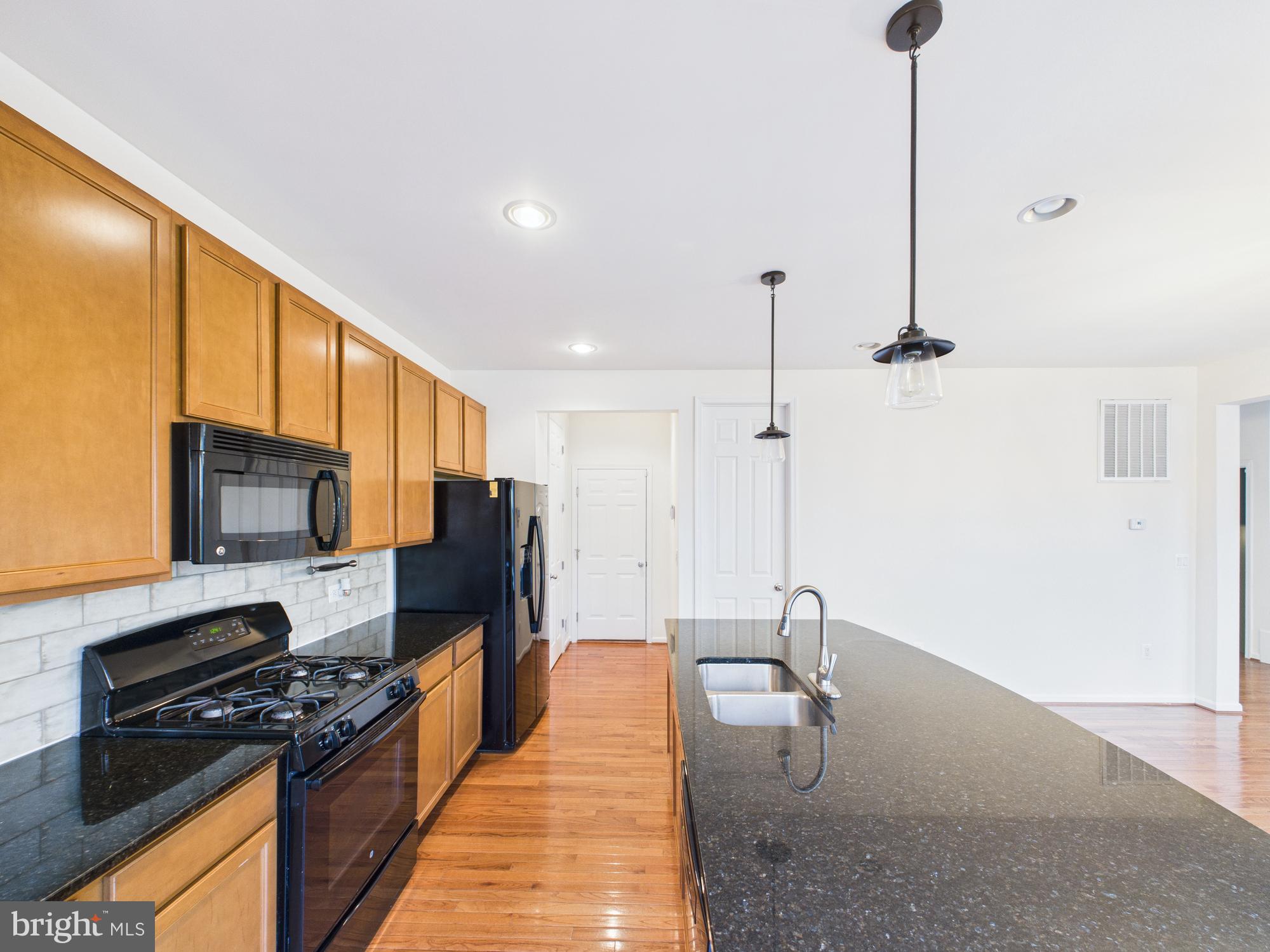 18213 Jillian Lane Triangle, VA 22172 - Photo 14 of 41 a kitchen with stainless steel appliances granite countertop a sink a stove and refrigerator