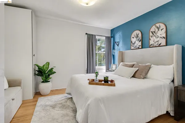 a bedroom with a bed a couch and a potted plant