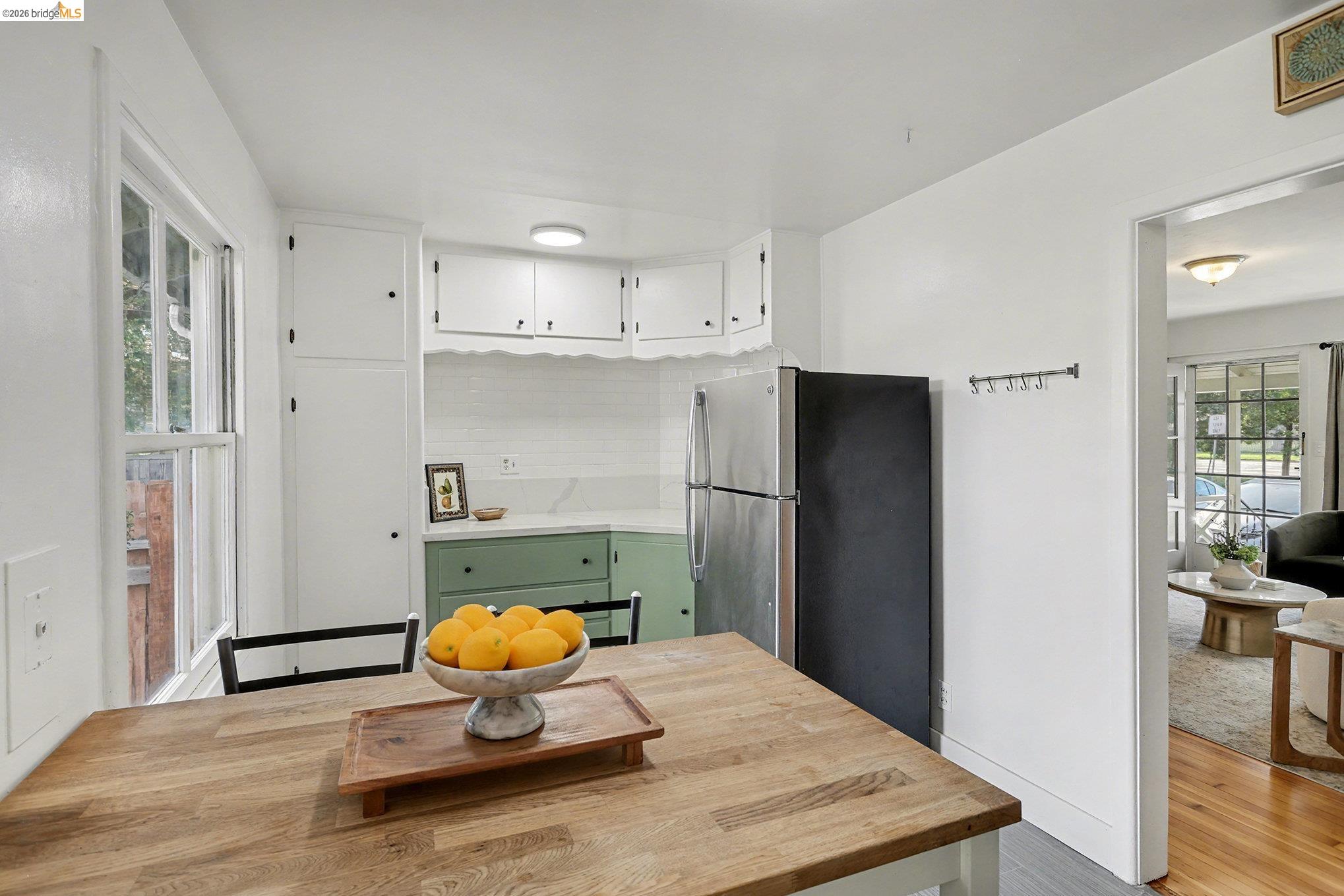 1808 Main Street Alameda, CA 94501 - Photo 9 of 18 Kitchen featuring light countertops, white cabinets, green cabinets, freestanding refrigerator, and light wood-type flooring