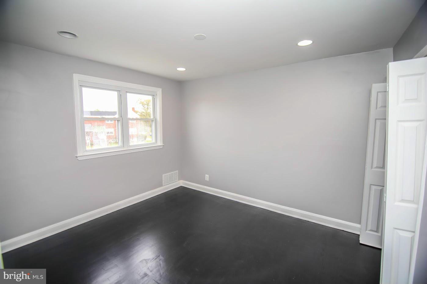 1962 Church Road Baltimore, MD 21222 - Photo 8 of 23 an empty room with wooden floor and windows