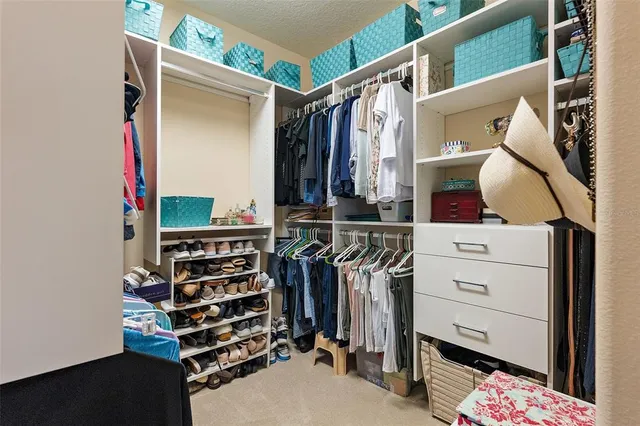 a view of walk in closet with clothes and shoes