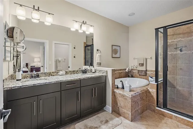 a bathroom with a double vanity sink mirror and bathtub