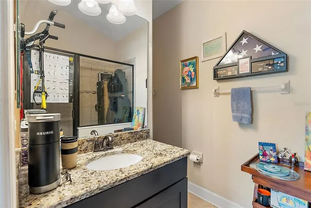 a bathroom with a granite countertop sink and a mirror