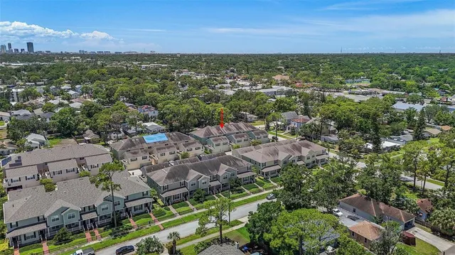 an aerial view of residential houses with outdoor space and ocean view