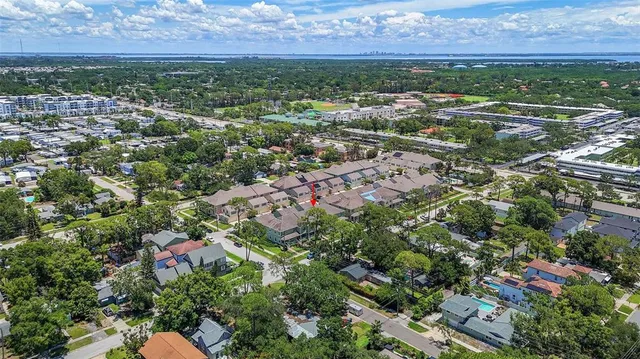 an aerial view of residential houses with outdoor space and trees