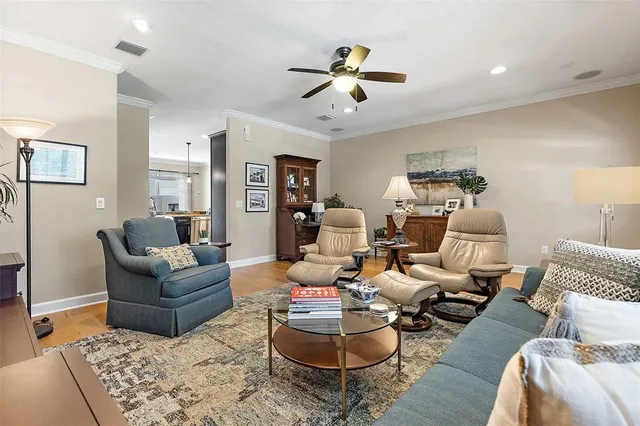 a living room with furniture or chandelier and a wooden floor
