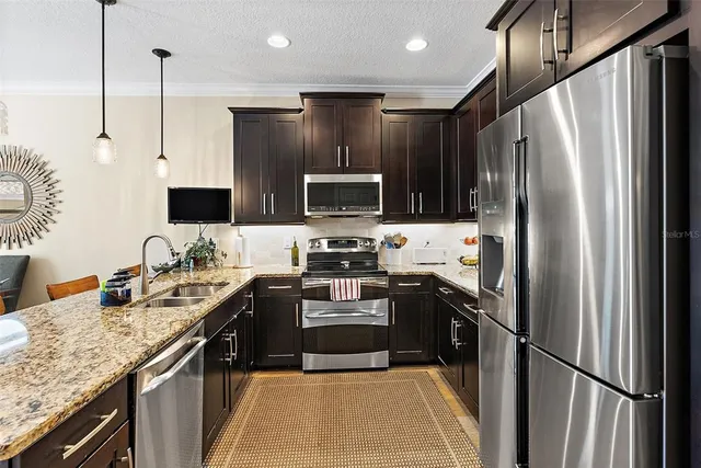 a kitchen with kitchen island granite countertop stainless steel appliances and a sink