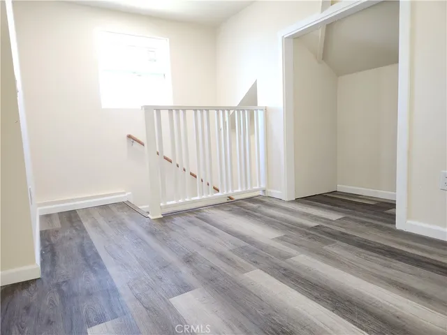 a view of a hallway with wooden floor and a window