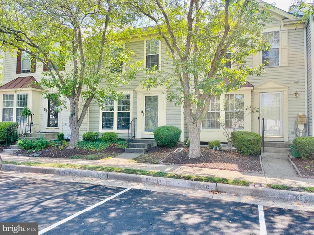 a view of a brick house with a large windows and large trees